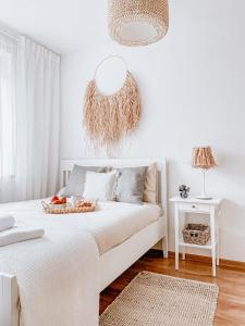 绿山城Apartamenty Flat White Ruczajowa的一间白色卧室,配有一张带篮子的床