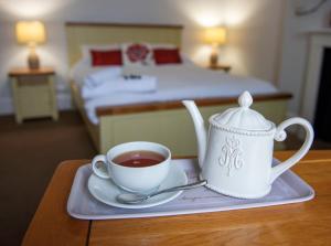 克里克莱德The Vale Hotel的卧室里的桌子上放着一杯茶和茶壶