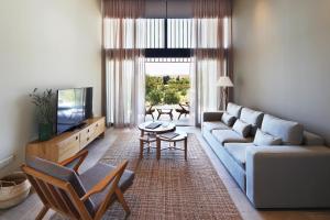 帕福斯Minthis Resort的客厅配有沙发和桌子