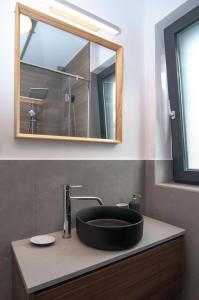 巴拉顿诺尔马迪Skyline Resort的浴室设有黑色水槽和镜子