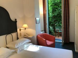 阿拉西奥布利瓦吉酒店的酒店客房,配有一张床和一张红色椅子