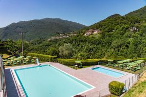提尼亚类Garnì Hotel Tignale, GTSGroup的享有游泳池的景色,背景为山脉