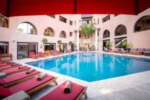 马拉喀什海微尼格spa酒店 的一座带椅子的大型游泳池和一座建筑