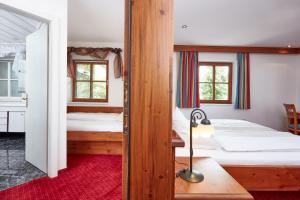 布利克森塔勒胡贝图斯酒店的一间带两张床的卧室和红色地毯