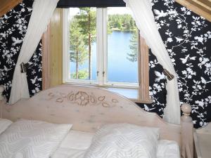 赖特维克Chalet Nedre Gärdsjö - DAN085 by Interhome的一间卧室设有一张床和一个美景窗户。