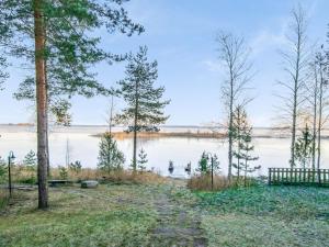 RuokolaHoliday Home Wilkkilä by Interhome的一条小径,旁边是种着树木和长凳的湖泊