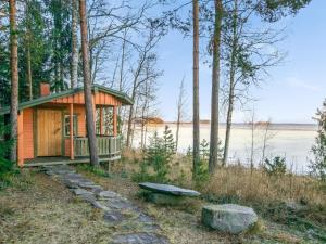 RuokolaHoliday Home Wilkkilä by Interhome的树林中的小屋,设有长凳和湖泊