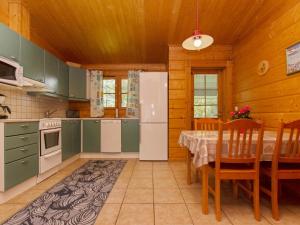拉赫登佩拉雅佩荷雷波度假屋的厨房配有桌子和白色冰箱。
