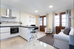 伊科德洛斯维诺斯Apartamento rolycar 103的厨房以及带沙发和桌子的客厅。