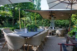 威廉斯塔德Hotel Mauritz的庭院里配有桌椅和遮阳伞