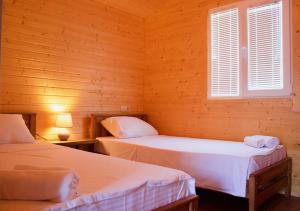 AkhmetyFinca Idoize Camping Hotel的配有木墙和窗户的客房内的两张床