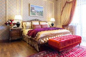 布加勒斯特Suter Palace Heritage Boutique Hotel的一间卧室配有一张床和一个红色的搁脚凳