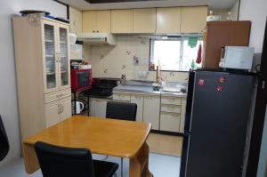 泉佐野MINPAKU-P 民泊p的一间带桌子和冰箱的小厨房