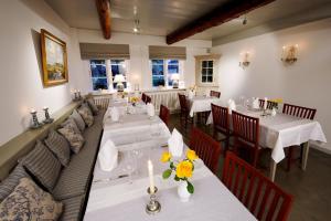 SüderendeLandhaus Altes Pastorat的餐厅设有桌子和长沙发,上面摆放着鲜花