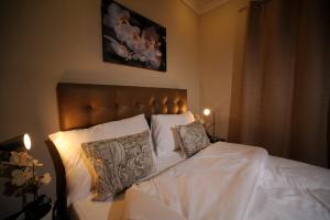 科威特莎米亚之家酒店的一间卧室配有带白色床单和枕头的床。