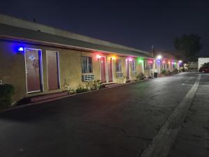 唐尼Deluxe Motel, Los Angeles Area的街上的一座建筑物,晚上有五颜六色的灯光