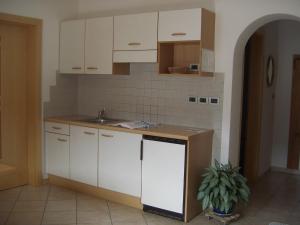 拉布拉Ferienwohnung im Haus Texel IV的厨房配有白色橱柜和水槽