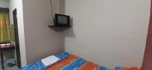 Cerro VerdeBosques del Tibet的小房间设有床铺和墙上的电视