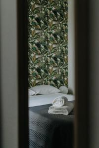 埃尔瓦斯Elvas the Queen Residence的床上的镜子反射,上面有一条毛巾