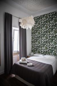埃尔瓦斯Elvas the Queen Residence的一间卧室配有一张床和一个吊灯