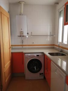 塞维利亚WISH SUITE MORERA的厨房配有洗衣机和水槽