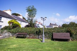 ArdglassBurford Lodge Guest House的公园里有两个长椅和街灯