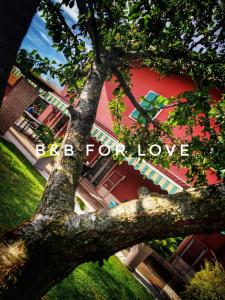 帕斯特伦戈伊尔特拉蒙多住宿加早餐旅馆的红楼前的树,上面有爱的字袋