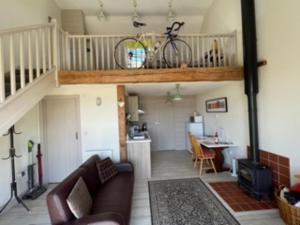 ShorwellBike Shed - Beautiful 1-Bed Cottage in Shorwell的客厅配有沙发,阁楼上设有自行车