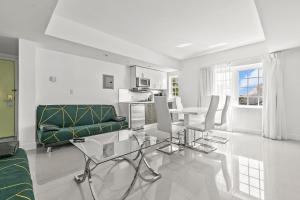 迈阿密海滩美人酒店的白色的客厅配有绿色的沙发和桌子