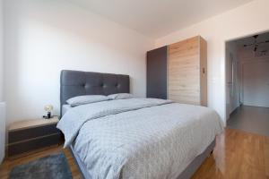 奥西耶克Apartman Pepper的一间卧室配有一张大床和灰色床头板