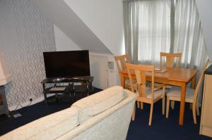 邓弗姆林Holiday Apartment Dunfermline的客厅配有沙发和带电视的桌子