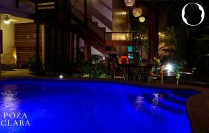 巴卡拉尔Poza Clara Sanctuary的夜晚带桌子的蓝色游泳池