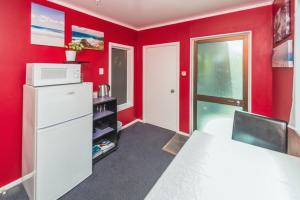 旺格努伊Anndion Lodge Motel & Conference Centre的红色客房配有冰箱和微波炉
