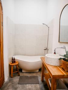 外南梦Betah Homestay Banyuwangi的带浴缸和盥洗盆的浴室