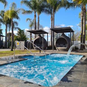 科罗瓦Federation Motel Resort - Corowa的公园内一个带两个喷泉的游泳池