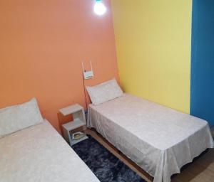 圣安娜-利弗拉门图Sobrado Livramento Rivera Diaria的一间设有两张床的客房,拥有黄色和橙色的墙壁