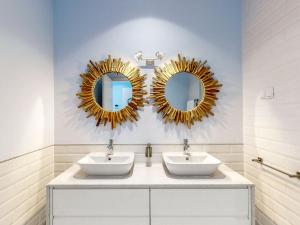 普拉亚达维多利亚Facing Bay Hostel的浴室设有两个水槽和墙上的镜子