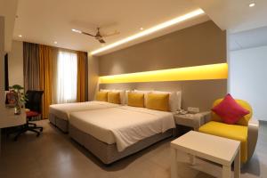 塞勒姆ZIBE Salem By GRT Hotels的酒店客房,设有两张床和一张黄色椅子