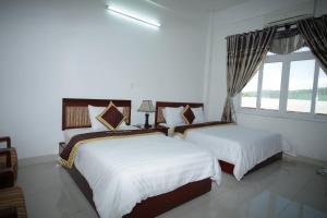 Lao BaoĐào Hùng Hotel的一间卧室设有两张床和窗户。