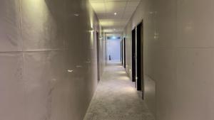 Neunkirchen am SandVOK Pension的一条带白色墙壁的走廊和一条带灯光的长走廊