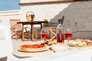 普蒂尼亚诺Tenuta Ulivi的一张桌子,上面放着两盘食物和酒杯