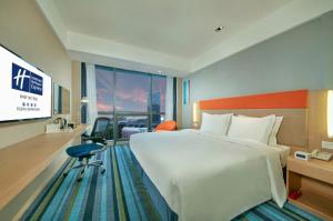 福州福州泰禾智选假日酒店的一间酒店客房,配有一张大床和一台平面电视