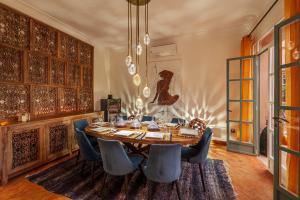马拉喀什Superbe Villa Y - Calme & sureté - Piscine privée & gouvernante的一间带木桌和蓝色椅子的用餐室