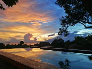 锡基霍尔Nakabalo Guesthouse & Restaurant的享有日落背景的游泳池