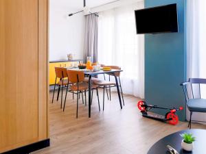 安锡阿纳西中心阿德吉奥公寓式酒店的用餐室配有桌椅和摩托车