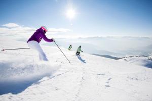 罗登戈Pension Volgger的两个人在雪覆盖的斜坡上滑雪