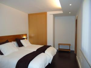 格拉纳达茂日旅行者公寓的卧室配有一张白色大床和木制床头板