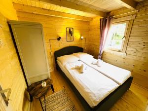 KamminkeInselglück Usedom的木制客房内的一间卧室,配有一张床