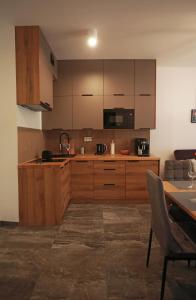 洛格沃Shellter Apartament Nadmorski的一个带木制橱柜和桌子的厨房