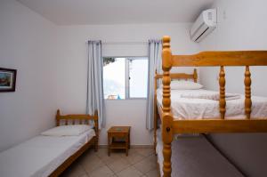 邦比尼亚斯坎托达斯佩德拉斯旅馆的一间卧室设有两张双层床和一扇窗户。